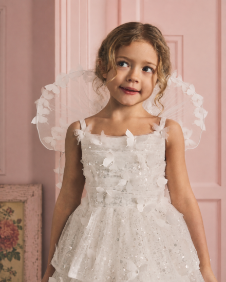 Mädchen in einem festlichen Kinderkleid mit Glitzer und Schmetterlingen